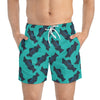 A man wearing aBlue green short swim trunks with fish print