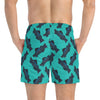 A man wearing a Blue green short swim trunks with fish print back view